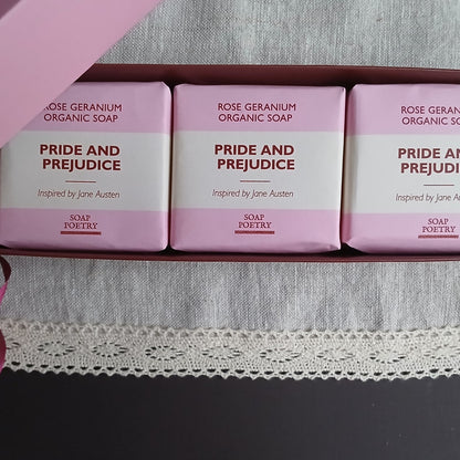 Three bars of 'Pride and Prejudice' soap inspired by Jane Austen on a pink background.