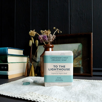Soap bar titled 'To The Lighthouse' on a table with books and flowers in the background