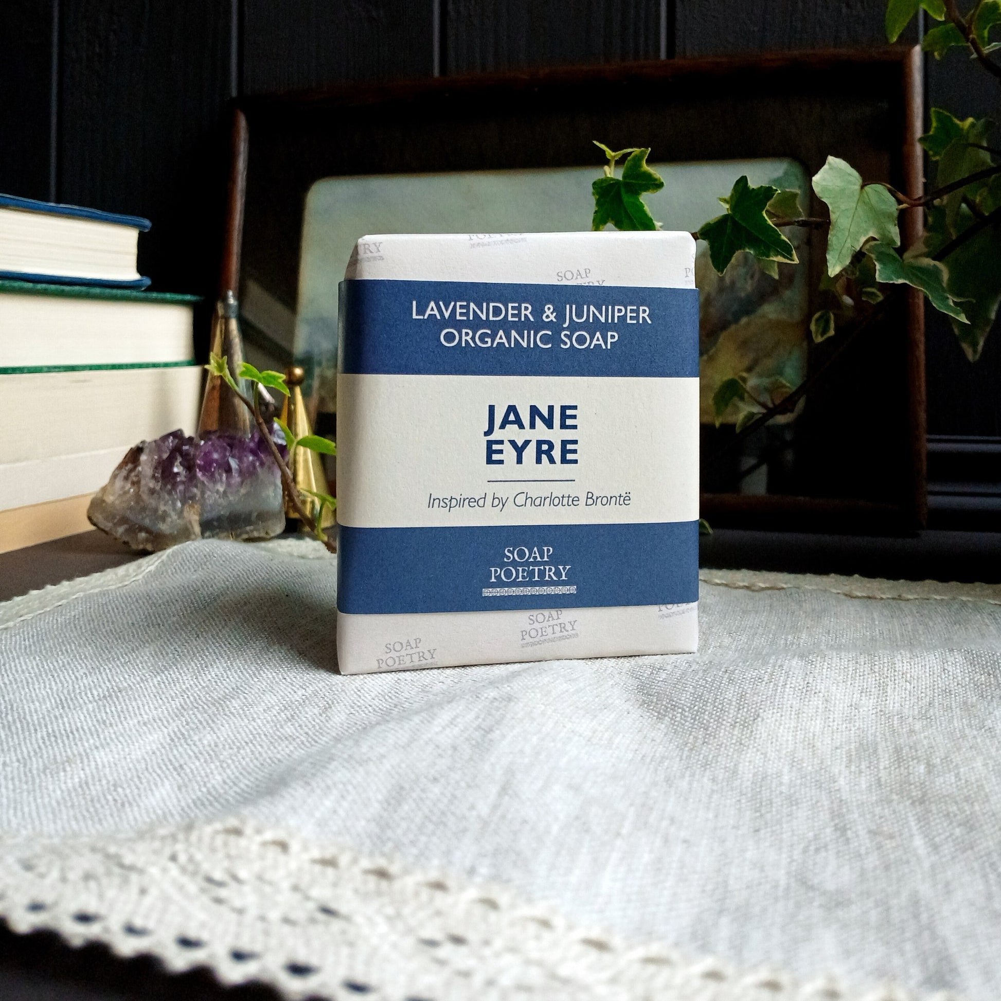 Bar of soap with 'Jane Eyre' packaging on a textured surface with books and plants in the background