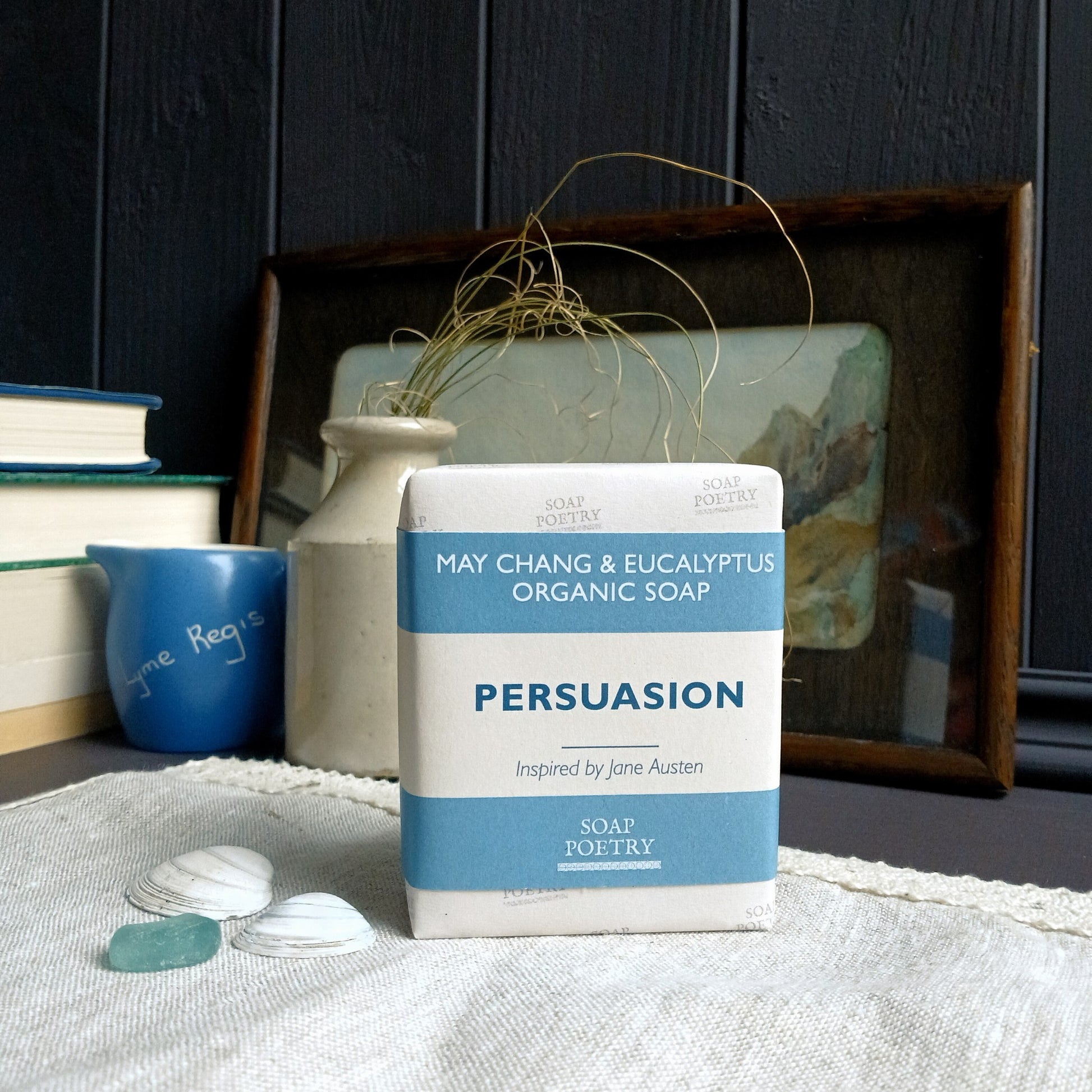 Bar of 'Persuasion' organic soap by Soap Poetry on a surface with books and decor in the background.