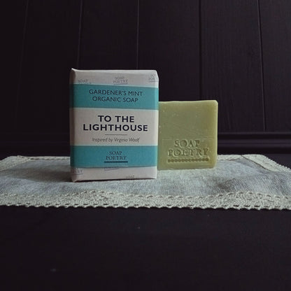 Bar of soap and packaging labeled 'To the Lighthouse' on a textured surface with dark background