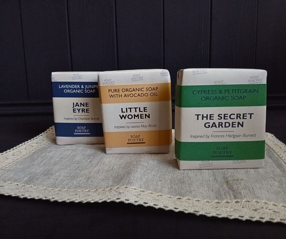 Three beautifully wrapped  organic soaps with book-themed names on a lace doily.