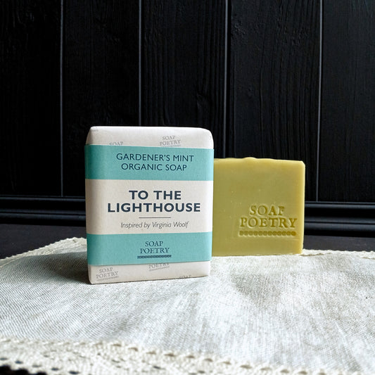 Bar of soap and packaging labeled 'To the Lighthouse' by Soap Poetry on a textured surface with dark wooden background.